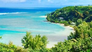 View of wave crashing onto sandy beach in Anini Beach in Kauai, Hawaii, USA